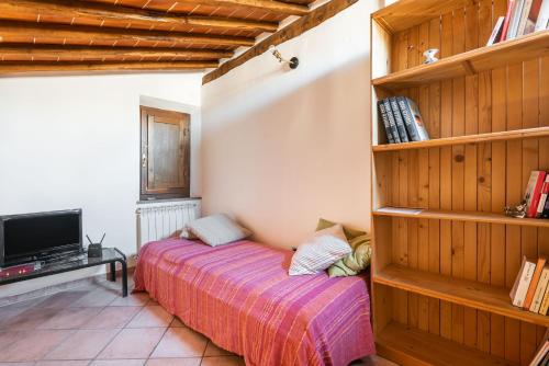 a bedroom with a bed and a book shelf at Rustic Tuscan Retreat A Cozy Escape Near Siena in Val di Pugna