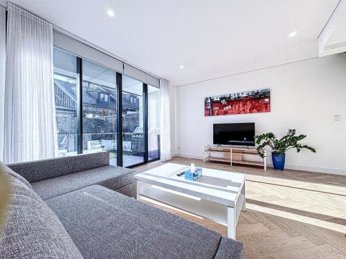 a living room with a couch and a tv at Modern 3BR Townhouse - Sleeps 10 - 2-Car Garage in Sydney