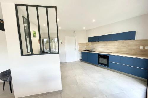 une cuisine avec des armoires bleues et un comptoir dans l'établissement Luxury Maison d'Architecte neuve de standing, à Larmor-Baden