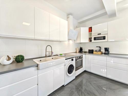 a white kitchen with a sink and a dishwasher at Loft für bis zu 12, Whirlpool, Infrarotsauna, Arcade-Spiele, Tischfußball, Wii in Nürnberg