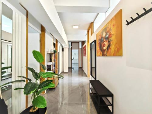 a hallway with a plant and a painting on the wall at Loft für bis zu 12, Whirlpool, Infrarotsauna, Arcade-Spiele, Tischfußball, Wii in Nürnberg