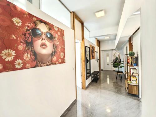 a hallway with a painting of a woman wearing sunglasses at Loft für bis zu 12, Whirlpool, Infrarotsauna, Arcade-Spiele, Tischfußball, Wii in Nürnberg