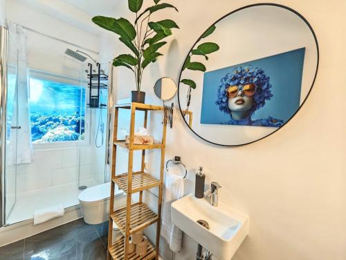 a bathroom with a mirror and a sink at Loft für bis zu 12, Whirlpool, Infrarotsauna, Arcade-Spiele, Tischfußball, Wii in Nürnberg