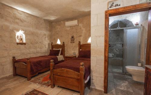 1 dormitorio con 2 camas y aseo en Maccan Cave Hotel, en Göreme