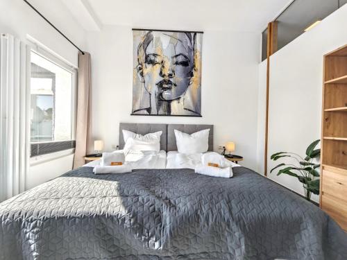 a bedroom with a large bed with a painting on the wall at Loft für bis zu 12, Whirlpool, Infrarotsauna, Arcade-Spiele, Tischfußball, Wii in Nürnberg