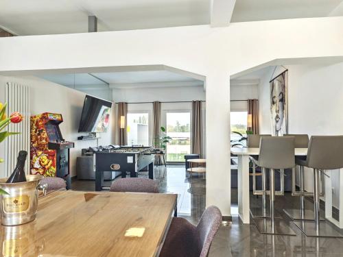 a dining room and living room with a table at Loft für bis zu 12, Whirlpool, Infrarotsauna, Arcade-Spiele, Tischfußball, Wii in Nürnberg