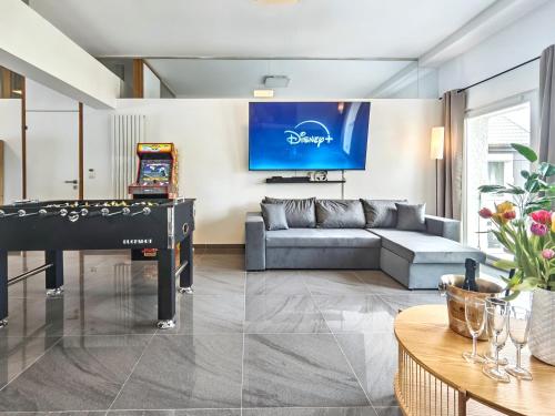 a living room with a couch and a pool table at Loft für bis zu 12, Whirlpool, Infrarotsauna, Arcade-Spiele, Tischfußball, Wii in Nürnberg