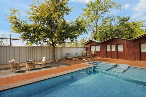 a backyard with a swimming pool and a house at Aahana Resort - Jim Corbett in Rāmnagar