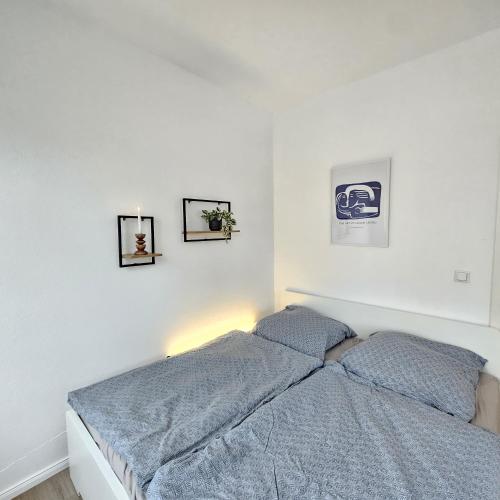 a bedroom with a bed and two pictures on the wall at Ziegel-Quartier APTNR 4 in Viersen