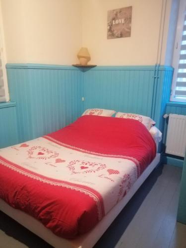 une chambre avec un lit avec une couverture rouge dans l'établissement L'arbre vert Les Locations de Stéphanie, à Sondernach