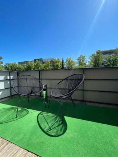 two chairs sitting on a balcony with a green rug at Toulouse Coconing & Peaceful Apartment in Toulouse