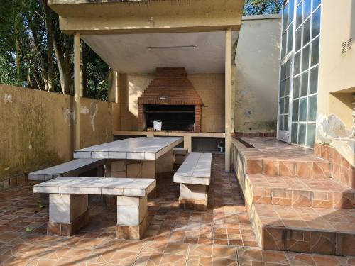 a patio with picnic tables and a brick fireplace at Casa Al pie del Cerro in Yerba Buena