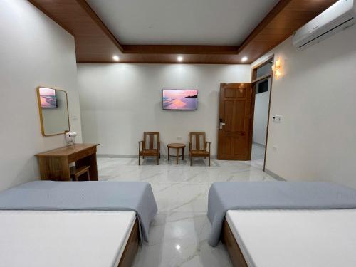 a bedroom with two beds and a table and chairs at Thảo Vân hotel in Sầm Sơn