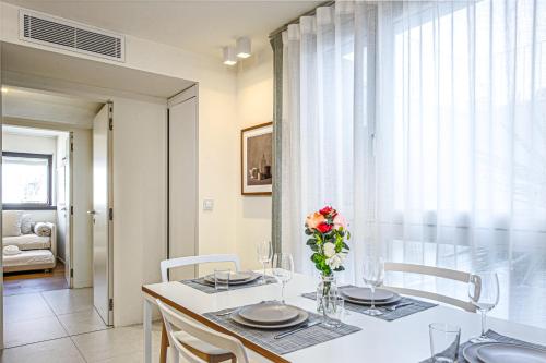 a dining room table with a vase of flowers on it at Porte de Monaco - Cozy 3 pièces - DE in Cap d'Ail