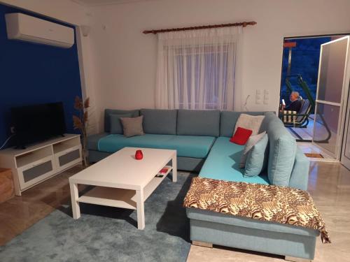 a living room with a blue couch and a table at Joel Apartment in Pefkali