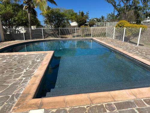 a swimming pool with blue water in a yard at Studio & piscine in La Saline les Bains