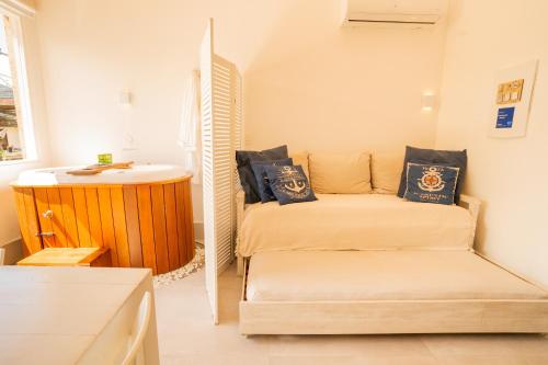 a small room with two beds and a sink at Casa d'Aroeira Residencial Boutique - Centro de Juqueí - 2 quadras do mar - Serviço de Praia - Roupa de Cama 600 fios algodão Egípcio - Toalhas Banho e Praia - Tudo Novo - Estacionamento Interno - Cozinha - Consulte unidades com Ofurô Hidro e Cromoterapia in Juquei