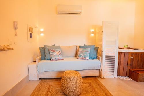 a bedroom with a bed with pillows and a table at Casa d'Aroeira Residencial Boutique - Centro de Juqueí - 2 quadras do mar - Serviço de Praia - Roupa de Cama 600 fios algodão Egípcio - Toalhas Banho e Praia - Tudo Novo - Estacionamento Interno - Cozinha - Consulte unidades com Ofurô Hidro e Cromoterapia in Juquei
