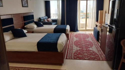 une chambre avec deux lits et un salon dans l'établissement Palma Resort A155 Chalet Hurghada, à Hurghada
