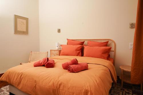 un lit avec deux animaux farcis rouges dans l'établissement Maison Pamplemousse, à Arles