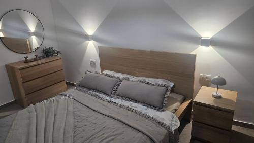 a bedroom with a large bed and a mirror at Apartman Odigitrija Old Town in Budva
