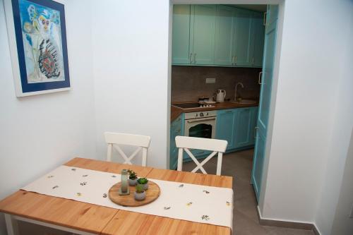 a kitchen with green cabinets and a wooden table at Apartman Odigitrija Old Town in Budva