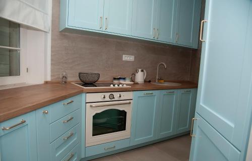 a kitchen with blue cabinets and an oven at Apartman Odigitrija Old Town in Budva