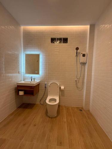 a bathroom with a toilet and a sink at The White Palm Villa & Pool in Khon Kaen