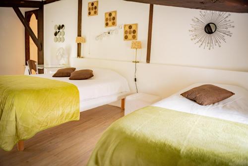 a bedroom with two beds with green and white sheets at Hôtel Henri IV - Restaurant in Eauze