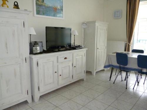 - un salon avec une télévision au-dessus d'une armoire dans l'établissement LA BAULE BORD DE MER APPT 2 pièces vue latérale mer 4 PERS, à La Baule