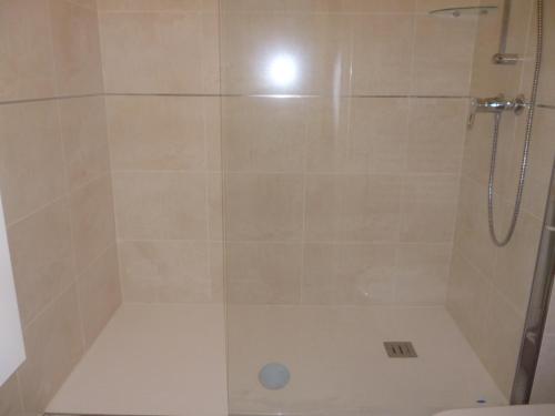 une douche avec une porte vitrée dans une salle de bain dans l'établissement LA BAULE BORD DE MER APPT 2 pièces vue latérale mer 4 PERS, à La Baule