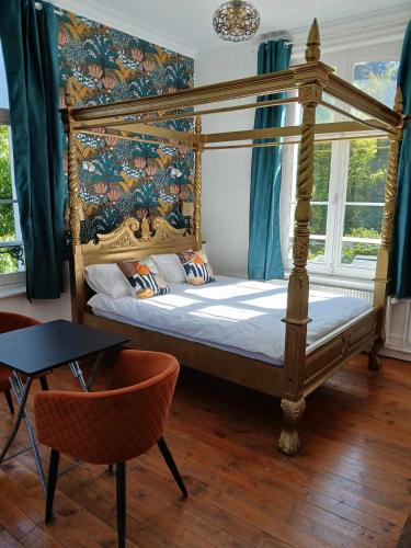 une chambre avec un lit à baldaquin et une table dans l'établissement Gîte Chateau baie de somme 10 a 12 personnes, à Mons-Boubert