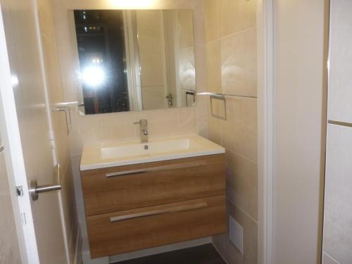 une personne prenant une photo d'une salle de bains avec lavabo dans l'établissement LA BAULE BORD DE MER APPT 2 pièces vue latérale mer 4 PERS, à La Baule