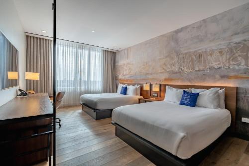 a hotel room with two beds and a desk at The Hotel & Athletic Club at Midtown in Chicago