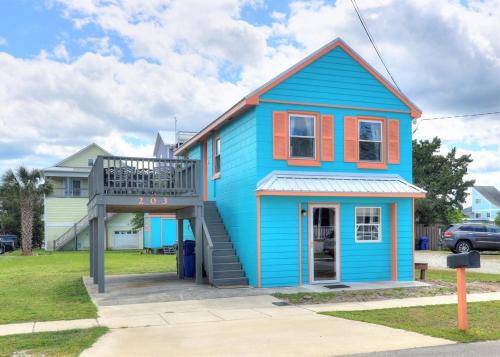 a blue house with a staircase in front of it at Turquoise Tunny by Carolina Beach Realty in Carolina Beach