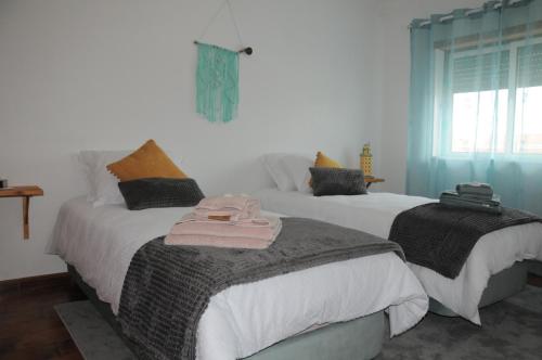 2 camas con toallas en un dormitorio en Casa da Costa de Lavos, en Figueira da Foz