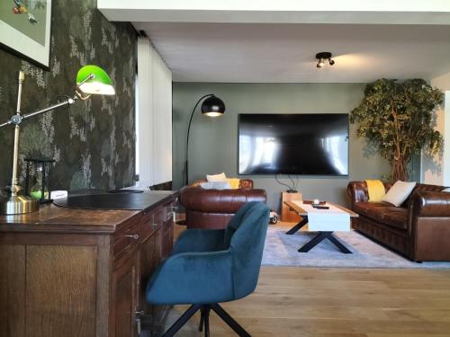 a living room with a couch and a tv at La seigneurie de Godefroy in Bouillon
