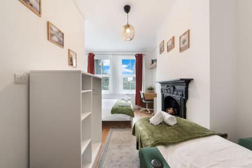 a bedroom with two beds and a fireplace at Stay on Brick Lane in London