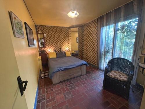 une chambre avec un lit, une chaise et une fenêtre dans l'établissement HomeBievres maison dans les bois, à Bièvres