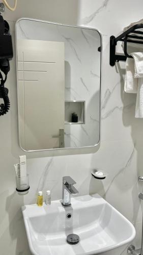 a bathroom with a white sink and a mirror at حلو الأماكن للشقق المخدومة-إقتصادي in Bisha