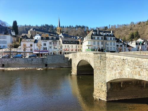 an old stone bridge over a river in a town at La seigneurie de Godefroy in Bouillon