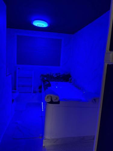 une salle de bains bleue pourvue d'une baignoire. dans l'établissement Logements jacuzzi silencieux, à Deuil-la-Barre