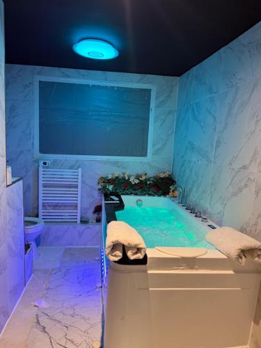 une grande salle de bain avec une baignoire et un lavabo dans l'établissement Logements jacuzzi silencieux, à Deuil-la-Barre