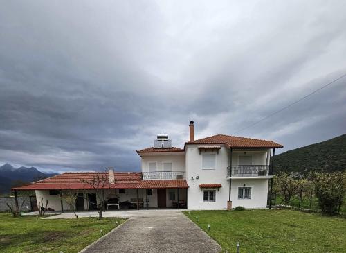 a large white house sitting on top of a field at Paikos Townhouse, Hot Springs in Konstantía