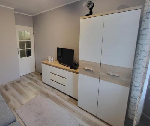 a room with a large white cabinet with a tv on it at Mieszkanie Starówka Centrum Iława in Iława