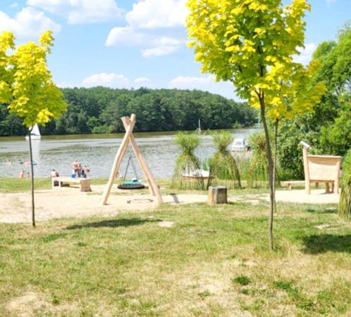 a park with a swing set next to the water at Mieszkanie Starówka Centrum Iława in Iława