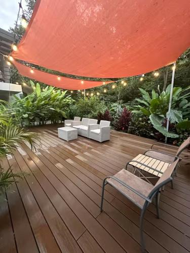 a patio with a bench and a red umbrella at Villa Carol in Punta Leona