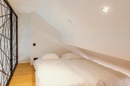 a white bed with two pillows in a room at CC Nomie Hôtel Restaurant in Dinant