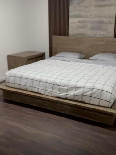 a bed in a bedroom with a wooden bed frame at Cozy 2 BR Apartment Glendale in Glendale