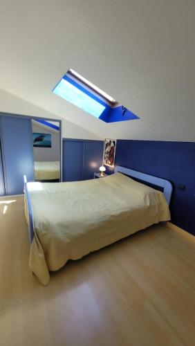 une chambre avec un grand lit avec une lucarne dans l'établissement Super Maison de pêcheur, au Barcarès